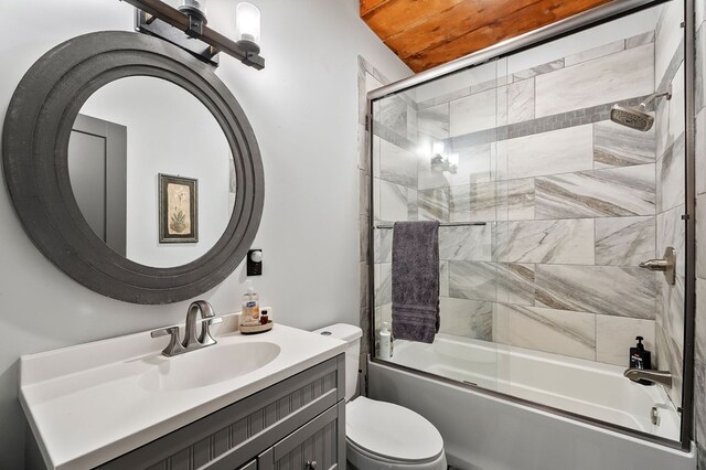 bathroom featuring vanity, toilet, and bath / shower combo with glass door