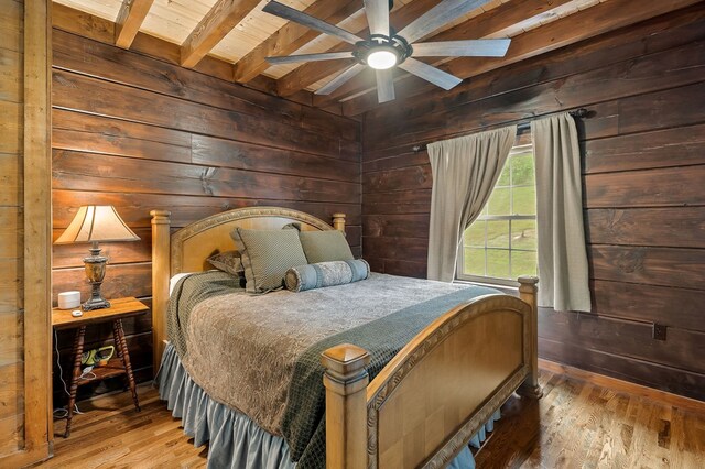 bedroom featuring wooden ceiling, wood finished floors, beam ceiling, and wooden walls