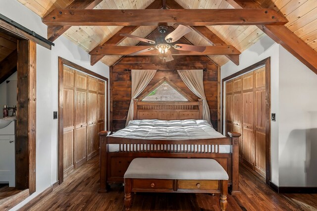 bedroom with lofted ceiling with beams, wooden ceiling, a barn door, and dark wood-type flooring