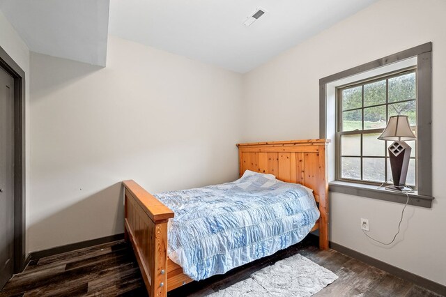 bedroom featuring dark wood-style flooring, visible vents, and baseboards