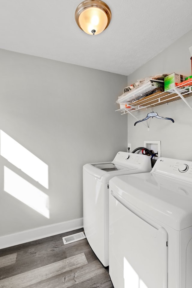 laundry room with laundry area, baseboards, visible vents, dark wood-style floors, and separate washer and dryer