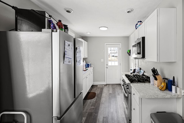 kitchen featuring a textured ceiling, dark wood-style flooring, white cabinetry, light countertops, and appliances with stainless steel finishes