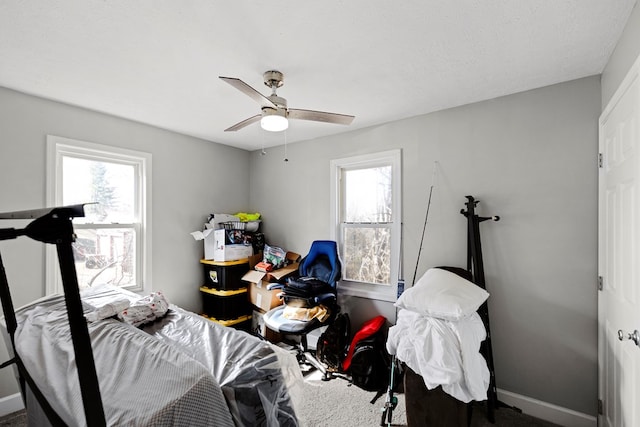 bedroom featuring ceiling fan, carpet floors, multiple windows, and baseboards