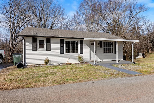 view of front facade with roof with shingles and a front yard