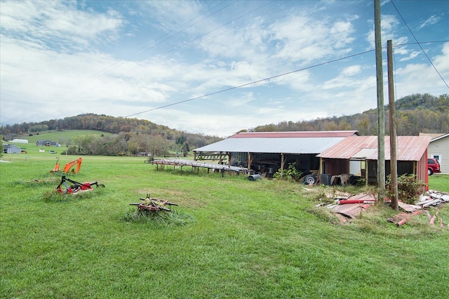 view of yard with an outbuilding, a rural view, and an outdoor structure