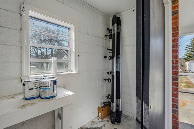 bathroom featuring concrete floors and concrete block wall