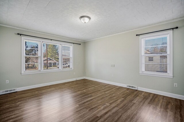 unfurnished room featuring visible vents, baseboards, dark wood-style flooring, and ornamental molding