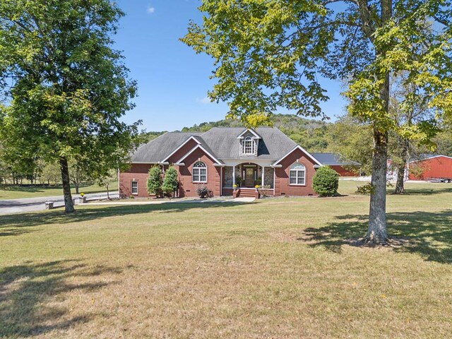 view of front facade featuring crawl space, covered porch, a front lawn, and brick siding