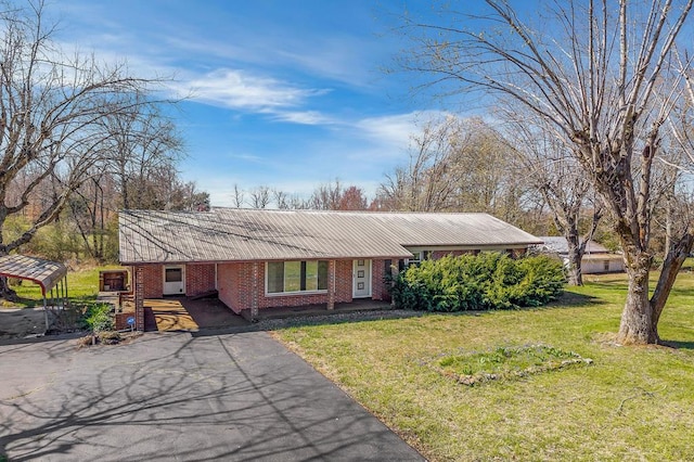 ranch-style home featuring brick siding and a front lawn