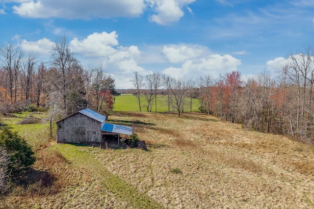 view of yard featuring an outbuilding, a barn, and a rural view