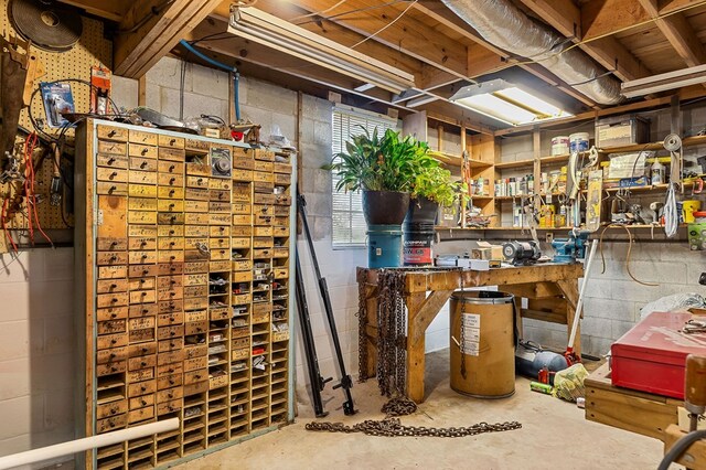 basement with a workshop area and concrete block wall