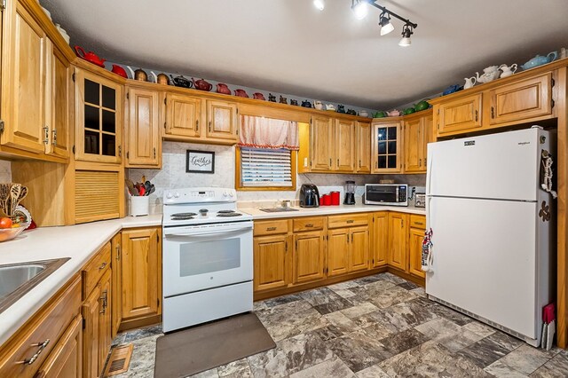 kitchen featuring white appliances, a toaster, glass insert cabinets, and light countertops