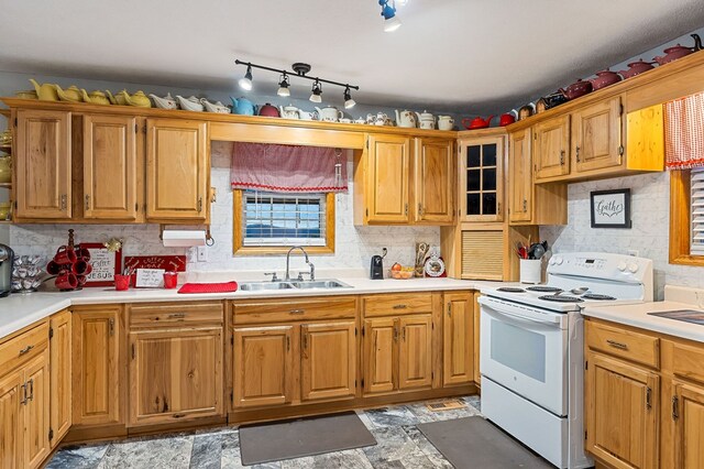 kitchen featuring brown cabinets, white electric range oven, light countertops, backsplash, and a sink