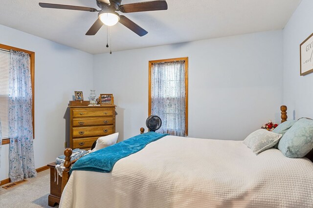 bedroom featuring light colored carpet, visible vents, ceiling fan, and baseboards