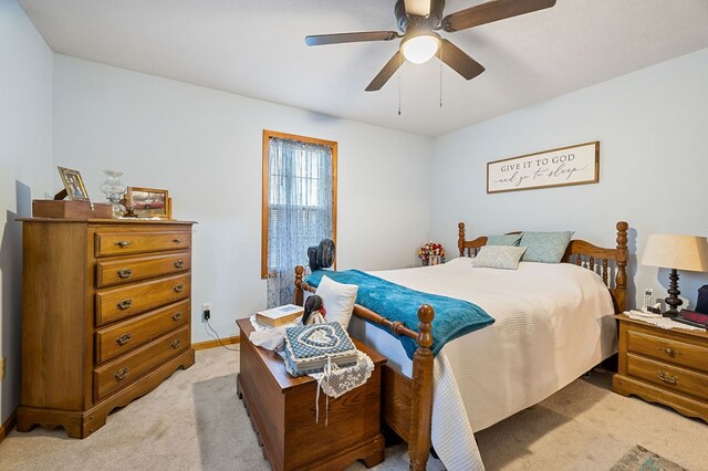 bedroom featuring a ceiling fan, light carpet, and baseboards