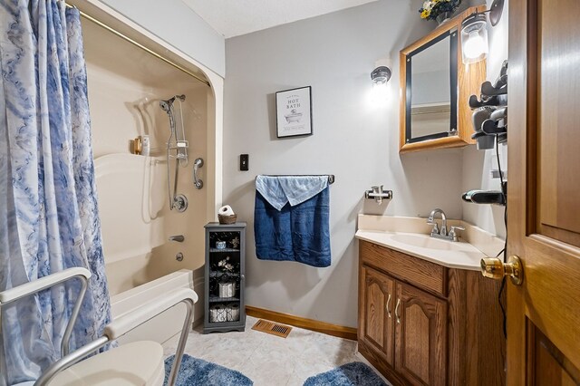 bathroom featuring visible vents, toilet, shower / bath combo, vanity, and baseboards