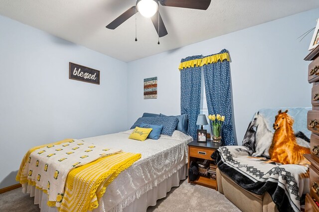 bedroom featuring light carpet and a ceiling fan