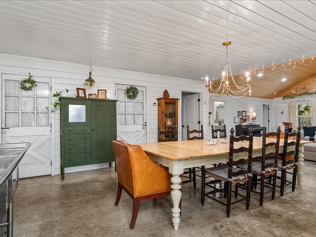 dining space with a chandelier, lofted ceiling, wooden ceiling, and concrete floors