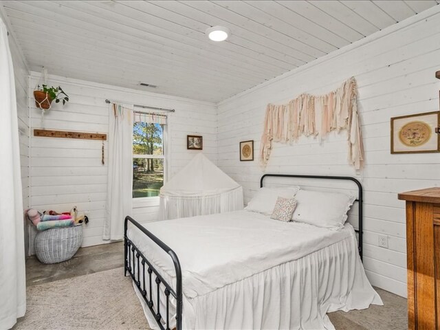 bedroom featuring wooden ceiling, visible vents, and wood walls