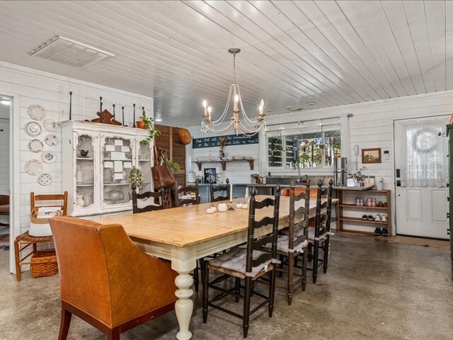 dining space with a chandelier, concrete floors, wooden ceiling, and visible vents