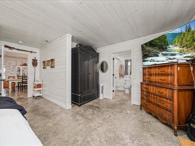 interior space featuring concrete floors, wooden ceiling, and ensuite bath