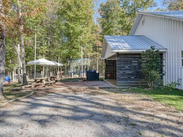 view of home's exterior with metal roof and a trampoline