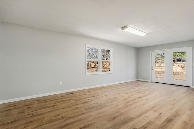 unfurnished room with visible vents, baseboards, and light wood finished floors