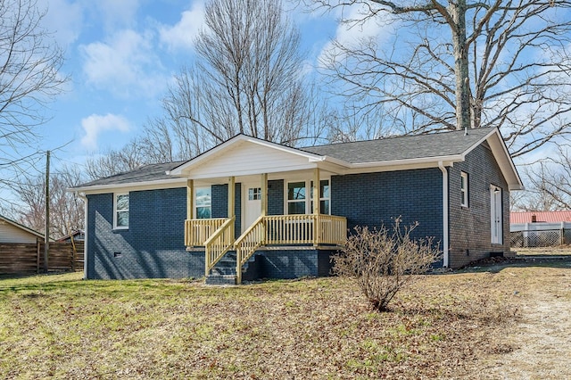 view of front of house with crawl space, covered porch, brick siding, and fence