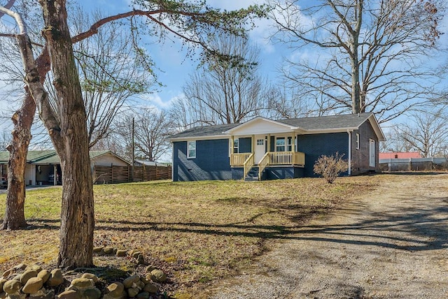 view of front of property with brick siding, a front lawn, and fence