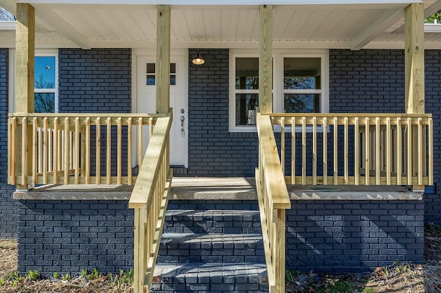 property entrance with brick siding and covered porch