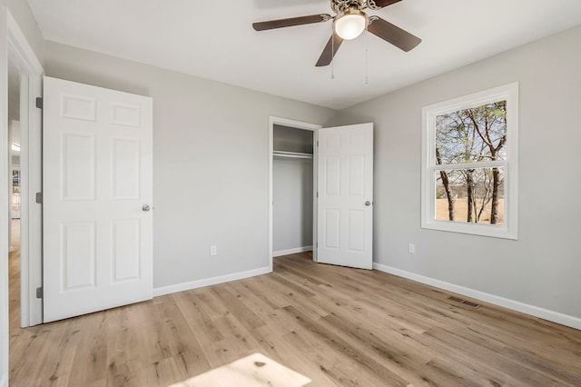 unfurnished bedroom with light wood-style floors, baseboards, visible vents, and a closet