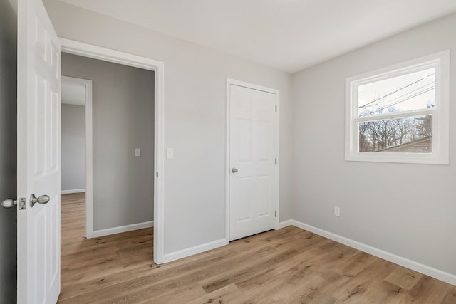 unfurnished bedroom featuring baseboards and light wood finished floors