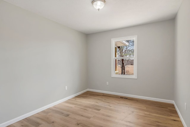 unfurnished room with light wood-style flooring, baseboards, and visible vents