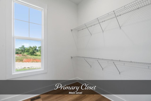 spacious closet featuring visible vents and wood finished floors