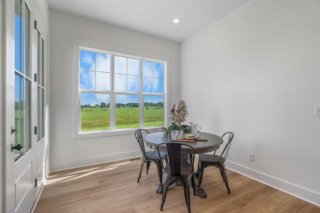 dining area featuring light wood finished floors, baseboards, and recessed lighting