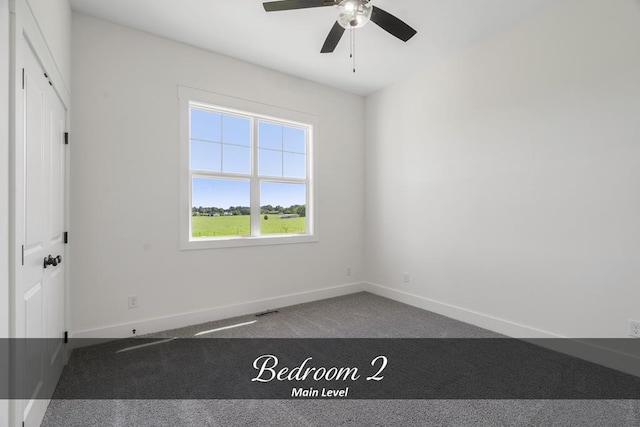 unfurnished room with a ceiling fan, carpet, and baseboards