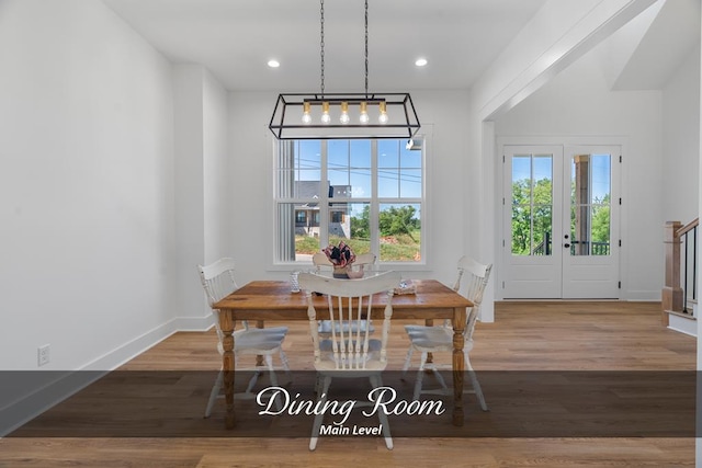 dining space with stairway, baseboards, wood finished floors, and recessed lighting