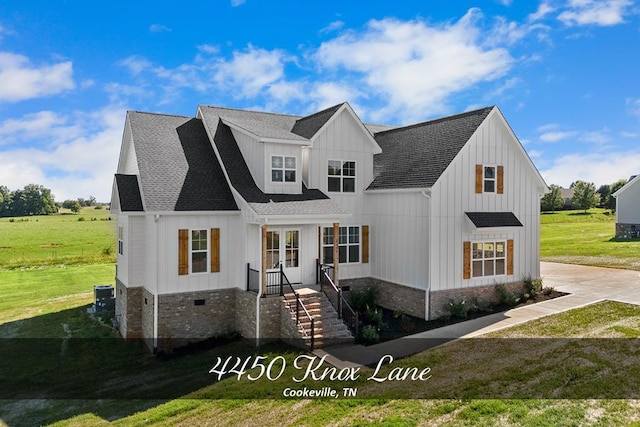 modern farmhouse featuring roof with shingles, central air condition unit, board and batten siding, a front yard, and crawl space