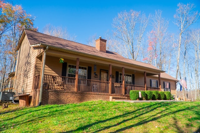 single story home with a front yard, covered porch, and a chimney