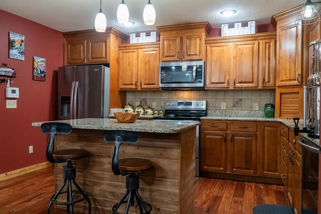 kitchen featuring a kitchen island, appliances with stainless steel finishes, and brown cabinets