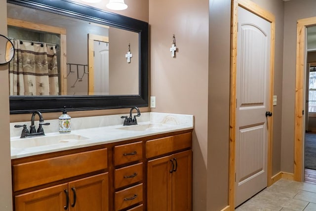 full bathroom with double vanity, curtained shower, a sink, and tile patterned floors