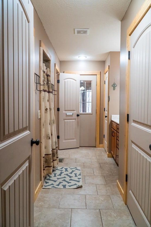 doorway featuring a textured ceiling and visible vents