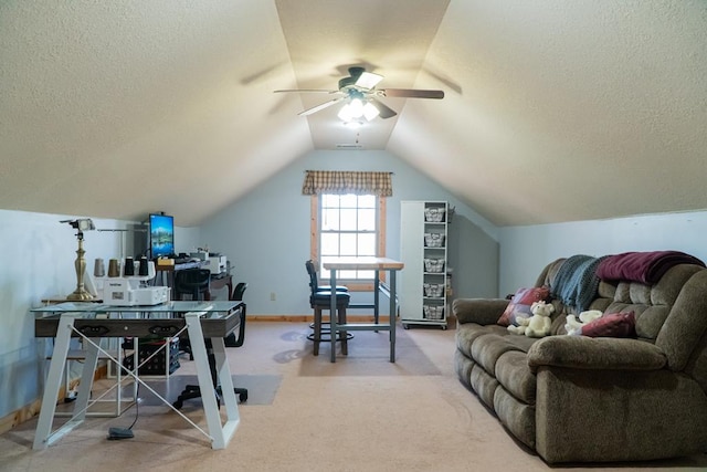 interior space with lofted ceiling, a ceiling fan, baseboards, and a textured ceiling