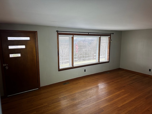 entrance foyer with baseboards, visible vents, and dark wood-style flooring