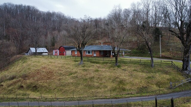 view of yard with fence and a rural view