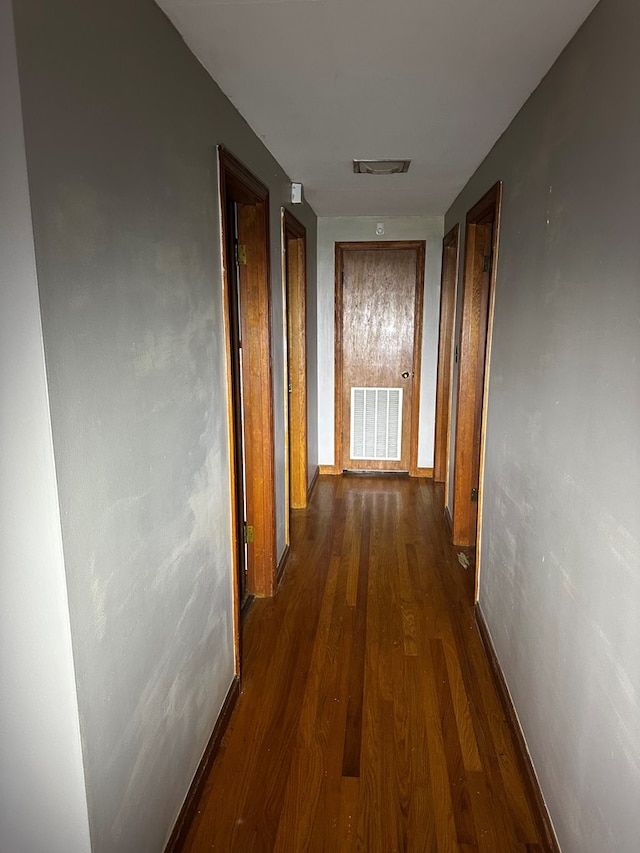 corridor featuring dark wood-type flooring and visible vents