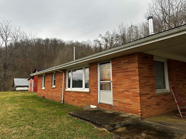 view of home's exterior with brick siding and a yard