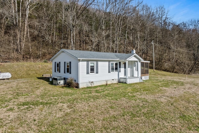 manufactured / mobile home featuring crawl space, a chimney, central AC unit, and a front lawn