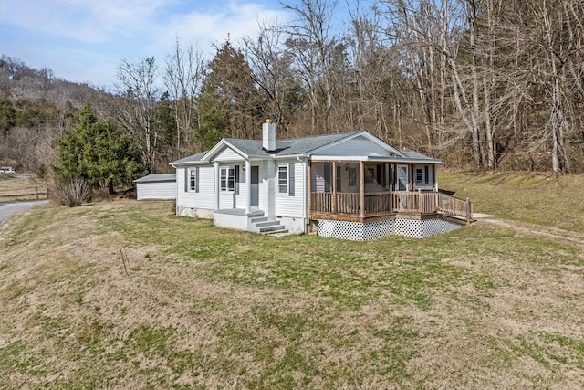 view of front of house featuring crawl space, a chimney, a front lawn, and roof with shingles