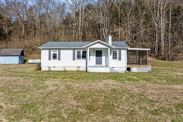 view of front of property featuring a chimney, crawl space, an outdoor structure, a shed, and a front lawn